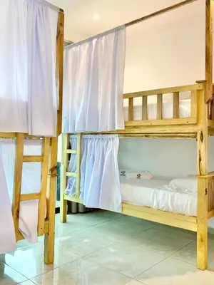 two bunk beds in a room with white curtains at Sunzal Surf Garden - El Tunco in Tamanique