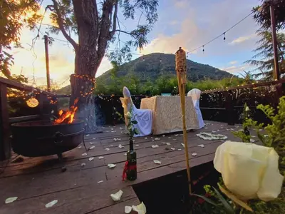 a patio with a fire pit and a table with wine bottles at Hotel Nido de Pájaro in Los Naranjos