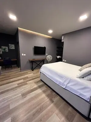 a bedroom with a bed and a flat screen tv at Hotel Nido de Pájaro in Los Naranjos