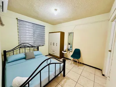 a bedroom with a bed and a window and a chair at Casa Virginia, AC, Close to Downtown, Private in Santa Ana