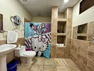 a bathroom with a toilet with a hello kitty shower curtain at Casa Virginia, AC, Close to Downtown, Private in Santa Ana