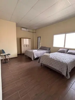a large room with two beds and a table at Casa Virginia, AC, Close to Downtown, Private in Santa Ana