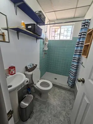a bathroom with a toilet and a green shower at New House in Ciudad Merliot in Hacienda Plan de La Laguna