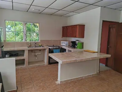 a kitchen with wooden cabinets and a counter top at Sueño del Pacifico in La Libertad