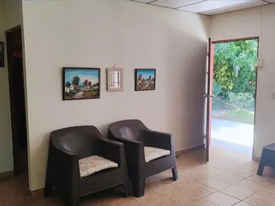 two chairs sitting next to a wall with pictures at Sueño del Pacifico in La Libertad