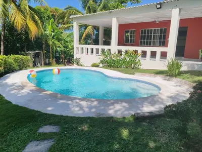 a swimming pool in front of a house at Sueño del Pacifico in La Libertad