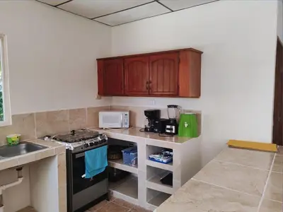a kitchen with wooden cabinets and a stove top oven at Sueño del Pacifico in La Libertad