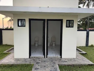 a white building with two toilets in it at Rancho El Valle in Acajutla