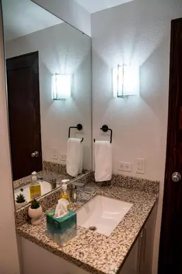 a bathroom with a sink and a large mirror at Apartment With Pool In Colonia Escalon in San Salvador