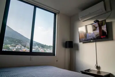a bedroom with a bed and a large window at Apartment With Pool In Colonia Escalon in San Salvador