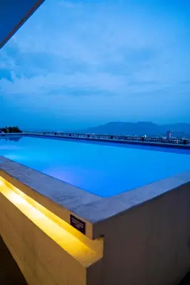 a large swimming pool with blue water at night at Apartment With Pool In Colonia Escalon in San Salvador