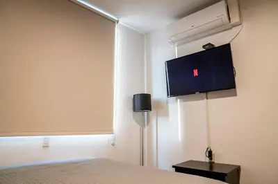 a bedroom with a bed and a tv on the wall at Apartment With Pool In Colonia Escalon in San Salvador