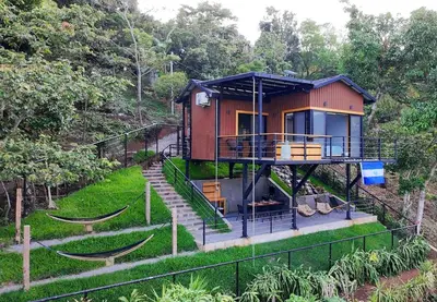 a house with a hammock in front of it at Dreamy cabin in Comasagua, La Libertad in Comasagua