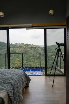 a bedroom with a camera on a tripod next to a bed at Dreamy cabin in Comasagua, La Libertad in Comasagua