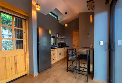 a kitchen with a stainless steel refrigerator and wooden cabinets at Dreamy cabin in Comasagua, La Libertad in Comasagua