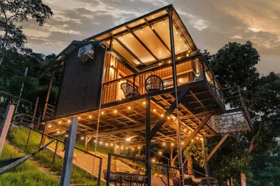 a tree house with lights on top of it at Dreamy cabin in Comasagua, La Libertad in Comasagua