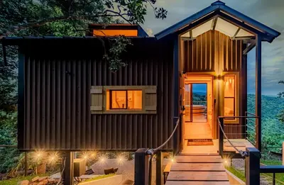 a small house with a wooden walkway to the door at Dreamy cabin in Comasagua, La Libertad in Comasagua