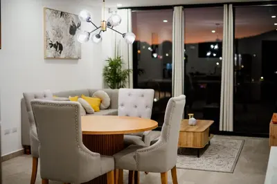 a dining room with a table and chairs and a couch at Apartment In The Greatest San Salvador in San Salvador