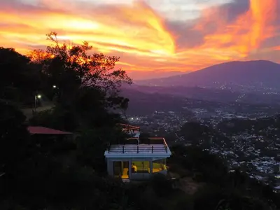 a house on a hill with a sunset in the background at Monticello in San Marcos