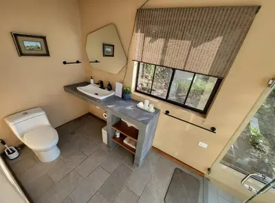 a bathroom with a toilet and a sink and a mirror at Monticello in San Marcos