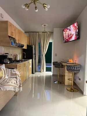 a kitchen with a bed and a tv on the wall at Golden House in San Miguel