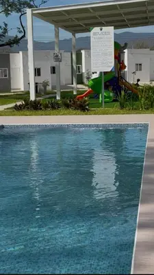 a swimming pool with a sign next to a water park at Golden House in San Miguel