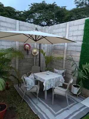 a table and chairs under an umbrella on a patio at Golden House in San Miguel