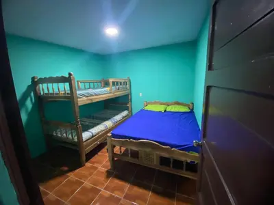 a bedroom with two bunk beds and a blue wall at Casa Apaneca in Apaneca