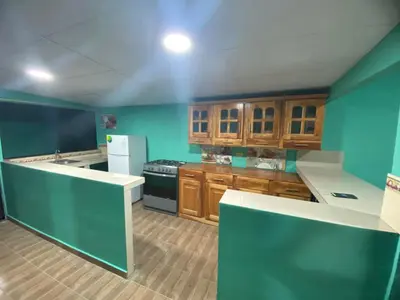 a kitchen with blue walls and wooden cabinets at Casa Apaneca in Apaneca
