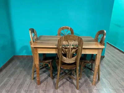 a wooden table with four chairs and a blue wall at Casa Apaneca in Apaneca