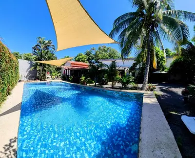 a swimming pool in front of a house with a palm tree at Copacabana SV L in El Majahual