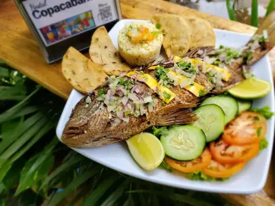a plate of fish with chips and vegetables on a table at Copacabana SV L in El Majahual