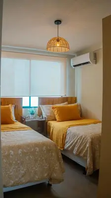 a bedroom with two beds and a window at Peach Haven 143 in San Juan Opico