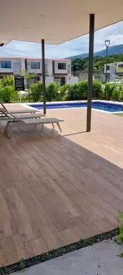 a picnic table on a patio with a view of a building at Peach Haven 143 in San Juan Opico