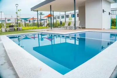 a swimming pool with blue water in a building at Peach Haven 143 in San Juan Opico