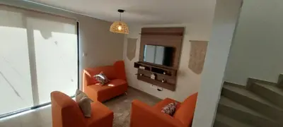 a living room with orange chairs and a television at Peach Haven 143 in San Juan Opico