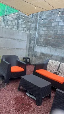 two chairs and a table in front of a brick wall at Peach Haven 143 in San Juan Opico
