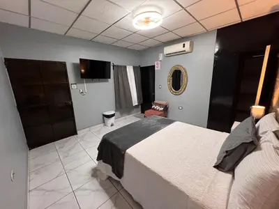 a bedroom with a large bed and a chair at Casa Victoria in San Miguel