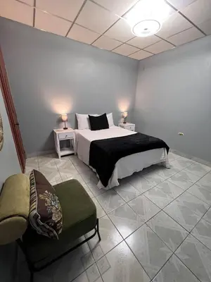 a bedroom with a large bed and a chair at Casa Victoria in San Miguel