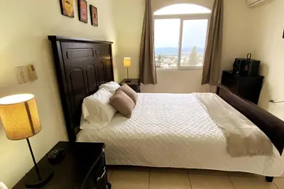 a bedroom with a large bed with a window at Beatiful Condo in Escalon near WTC building and Masferrer in San Salvador