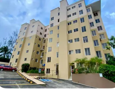 a large yellow building with a car parked in a parking lot at Beatiful Condo in Escalon near WTC building and Masferrer in San Salvador
