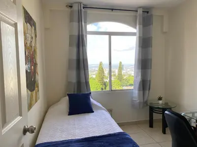 a bedroom with a window with a bed and a table at Beatiful Condo in Escalon near WTC building and Masferrer in San Salvador