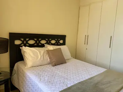 a bedroom with a bed with white sheets and pillows at Beatiful Condo in Escalon near WTC building and Masferrer in San Salvador