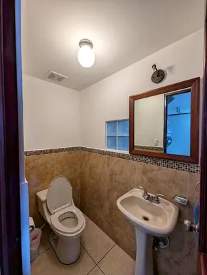 a bathroom with a toilet and a sink and a mirror at Habitaciones Privadas en Memories Flowershop - Colonia Escalón, Plaza Futura in San Salvador