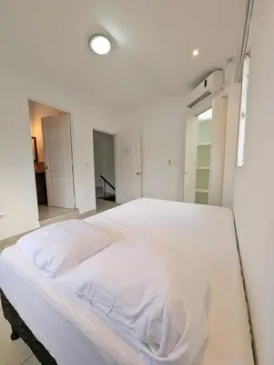 a large white bed in a white room at Habitaciones Privadas en Memories Flowershop - Colonia Escalón, Plaza Futura in San Salvador