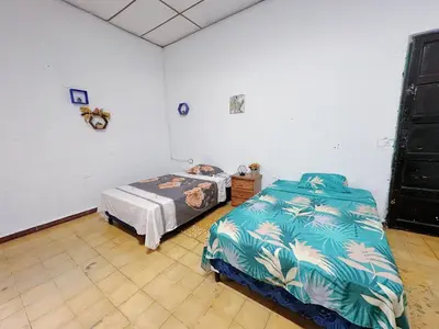 a bedroom with two beds in a room at Hostal Los Milagros in Santa Ana
