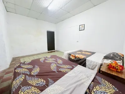 a room with two beds in a room at Hostal Los Milagros in Santa Ana