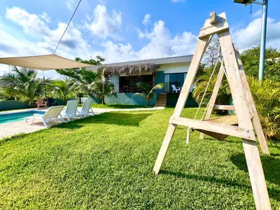 a wooden ladder sitting on the grass next to a house at Casa de lujo- Vista- Piscina- La Libertad in La Libertad