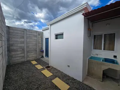 a white building with a sink and a fence at Casa en Villa Panamericana, San Miguel in San Miguel