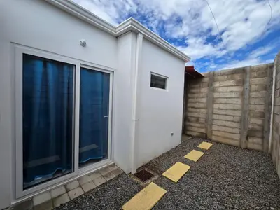 a white house with a fence at Casa en Villa Panamericana, San Miguel in San Miguel